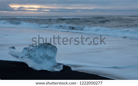 Icebergs on ice beach at foot of glacier Iceland at sunset