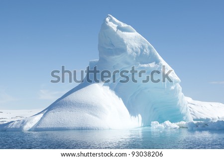 Icebergs in the sunny bright light on the background of the island.