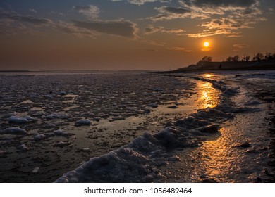
Ice-bound large river at sunset time.