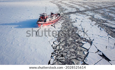 Icebreaker crushing ice in winter on Vistula River in Poland. Aerial view of winter in nature