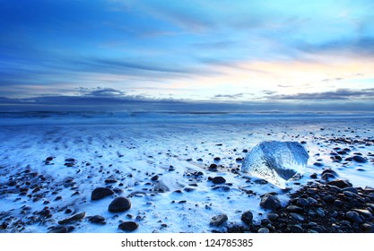 Iceburg on vocanic black sand beach at sunset in south Iceland - Powered by Shutterstock