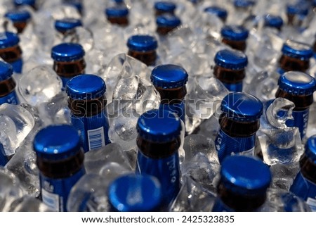 ice-cold alcoholic beverages for night parties, ice-cold alcoholic beverages, alcoholic beverage, beer bottle row in texture background. Glass containers with caps 