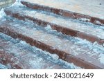 Ice-covered steps on the stairs. Bad weather in winter. Icy sidewalk, dangerous to walk, risk of slipping and falling.