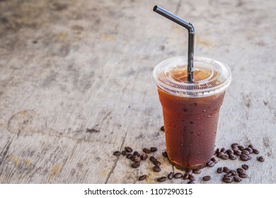 Iced Americano Black Coffee On Old A Wooden Desk With Coffee Beans