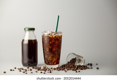 Iced americano coffee with coffee beans on grey background, Black coffee glass package for takeaway. Cold beverage product. - Shutterstock ID 2052014444