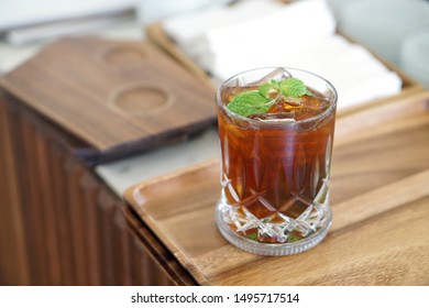 Iced Black Coffee Mojito - A Glass Of Cold Brew Coffee Mixed With Brown Sugar, Tropical Fruit And Mint On Blurred Background, Barista Making Coffee Cocktail, Perfect Drink For Summer Time.