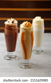 Iced Caramel Latte Coffee In A Tall Glass With Syrup And Whipped Cream.
White Chocolate Milkshake In Tall Glass Decorated Whipped Cream.
