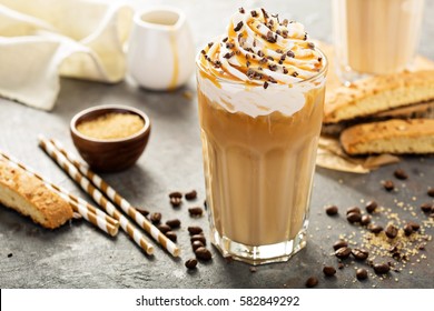 Iced caramel latte coffee in a tall glass with syrup and whipped cream. - Powered by Shutterstock