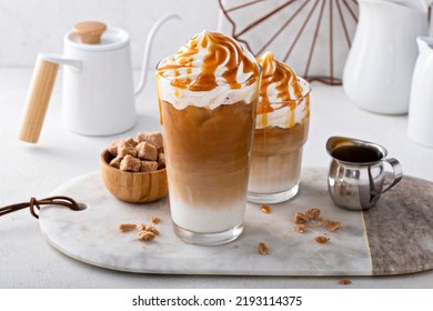 Iced caramel latte topped with whipped cream and caramel sauce, refreshing and sweet coffee drink - Shutterstock ID 2193114375