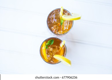 Iced Chilled Drink Tea Cocktail With Lemon Garnish And Yellow Straw On The Balcony White Background Top Down View