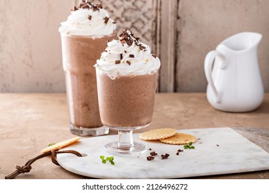 Iced chocolate coffee frappe topped with whipped cream and chocolate shavings