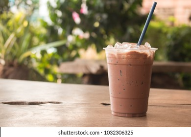 Iced chocolate milkshake, Summer refreshment drinks on wooden background in cafe.