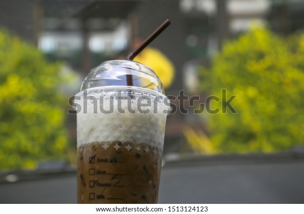 Iced coffee drinks From\
the coffee shop in the in the gas station that isw the car stop\
With the fresh  fresh background of cool green trees Relaxing in\
the morning.
