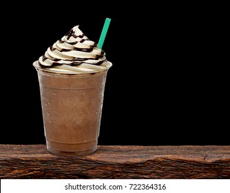 Iced Coffee Or Frappuccino With Cream In Takeaway Disposable Cup On Wooden Table With Black Background.