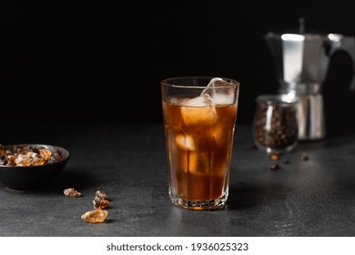 Iced coffee in a glass on black background. Cold refreshment coffee summer drink. - Shutterstock ID 1936025323