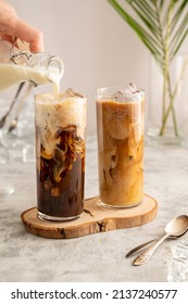 Iced coffee in glass. Pouring milk in glass with coffee. Summer drinks