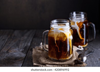 Iced Coffee With Milk In Mason Jars  On The Table