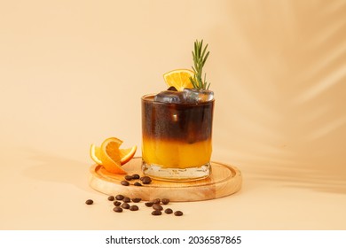 Iced coffee mixed with orange juice, two tones layer decoration with rosemary and piece of orange - Shutterstock ID 2036587865