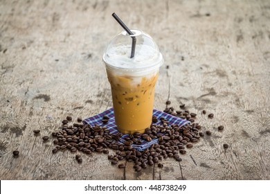 Iced Coffee On Old Wood Desk With Coffee Beans