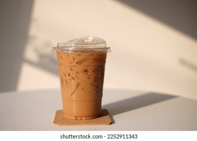 Iced coffee in a plastic cup with a mellow flavor under the morning sunlight. - Shutterstock ID 2252911343