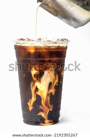 Iced cold brew coffee in a glass with milk poured over.