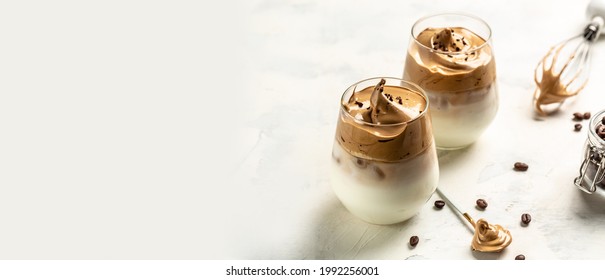 Iced Dalgona Coffee, Korean coffee drink instant coffee or espresso powder whipped. trendy fluffy creamy whipped coffee. Long banner format. top view.