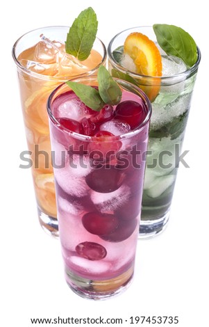 iced drinks with cherry, orange and mint on white background
