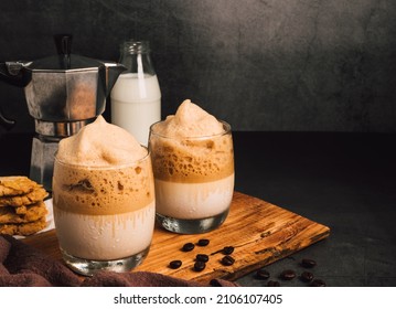 Iced or frappe, foam coffee smoothie on a glass cup and Roasted coffee beans, Italian Moka coffee pot maker, and milk on black marble backdrop. Copy space for your text - Powered by Shutterstock