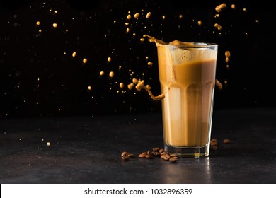 Iced Latte Coffee Glass With Splash On A Black Background