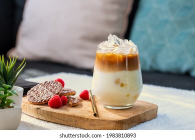 Iced latte coffee at home. Refreshing drink for summer. A glass of iced coffee latte with chocolate cookies on coffee table near the window in the living room. Drink background copy space. - Shutterstock ID 1983810893