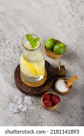 Iced Lemon With Sparkling Soda Water On Wooden Coaster And White Background Texture