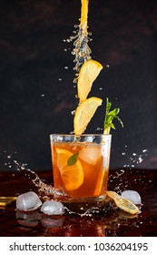 Iced Lemon Tea On Dark Background In Glass And Flying In Air Ingredients. Levitation Effect. Summer Cold Iced Tea. Food In Motion Concept. Splash