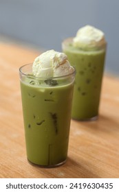 Iced matcha drink with vanilla float or ice cream on wooden table. Perfect for recipe, article, catalogue, or any commercial purposes.