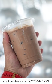 Iced Mocha Coffee In Clear Plastic Cup On Hand. Close Up