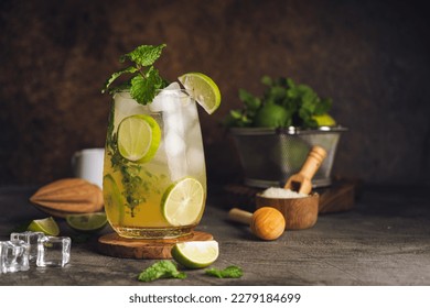 Iced Mojito cocktail long rum drink with fresh mint, fresh thyme, lime juice, cane sugar and soda on dark abstract background. Summer iced beverage and cocktail - Powered by Shutterstock