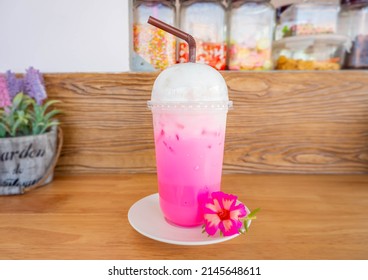 Iced pink milk favorite drink in Thailand. Sweet drink red sugar syrup with fresh milk and milk foam in plastic glass for delivery drink menu in coffee shop or Cafe now popular in Thailand.