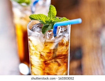 Iced Tea With Blue Straw And Mint Garnish