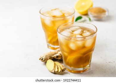Iced tea with lemon, ginger and brown sugar in glasses. Space for text.