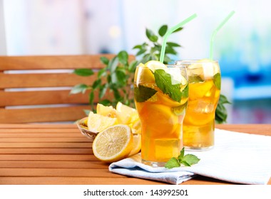 Iced Tea With Lemon And Mint On Wooden Table, Outdoors