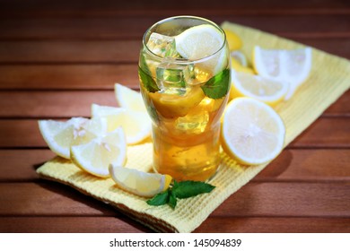 Iced Tea With Lemon And Mint On Wooden Table