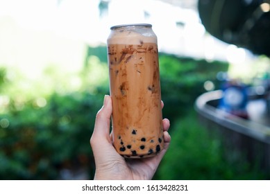 Iced Thai Milk Tea With Bubble Pearls. Hand Holding Can/bottle Of Thai Milk Tea With Brown Sugar Syrup And Boba/bubble Tapioca Pearls.