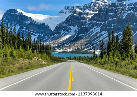 Icefields Parkway at Bow Lake - A Spring evening view of Icefields Parkway extending towards Bow Lake, with BowCrow Peak, Crowfoot Glacier and Crowfoot Mountain rising high behind, Banff National Park