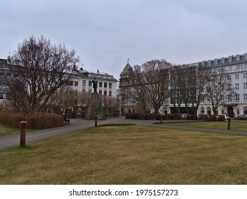 Reykjavík, Iceland - 04-02-2021: View Of Historic Square Austurvöllur In Reykjavik Downtown With Old Building, Bare Trees And The Monument Of Jón Sigurðsson On Cloudy Day In Winter Season.