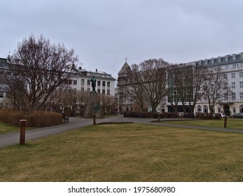 Reykjavík, Iceland - 04-02-2021: View Of Historic Square Austurvöllur In Reykjavik Downtown With Old Building, Bare Trees And The Monument Of Jón Sigurðsson On Cloudy Day In Winter Season.