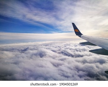 Reykjavík, Iceland - MARCH 25 2017: Airplane window seat's view of Icelandic's flight over the fluffy clouds and brilliant blue sky 