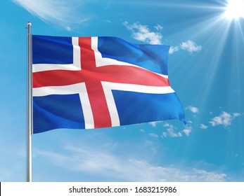 Iceland national flag waving in the wind against deep blue sky. High quality fabric. International relations concept.