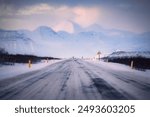 Iceland Ring Road Route 1, during winter, on a beautiful sunny evening, with mountains in the background, asphalt covered with snow, desolate, unknown, mysterious