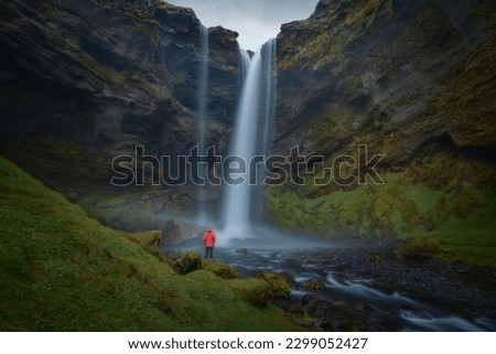 Iceland waterfall Kvernufoss hidden in a gorge Kvernugil by a river Kverna with standing girl