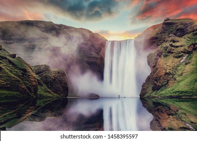 Icelandic Landscape. Classic long exposure view of famous Skogafoss waterfall with reflections. Dramatic Scenery of Iceland during sunset. majestic Skogafoss Waterfall in countryside with colorful sky