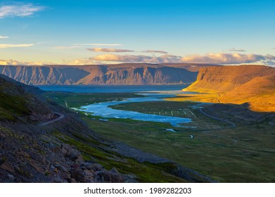 Icelandic landscape with a fjord and gravel road photographed at sunset in the Westfjords region of Iceland.